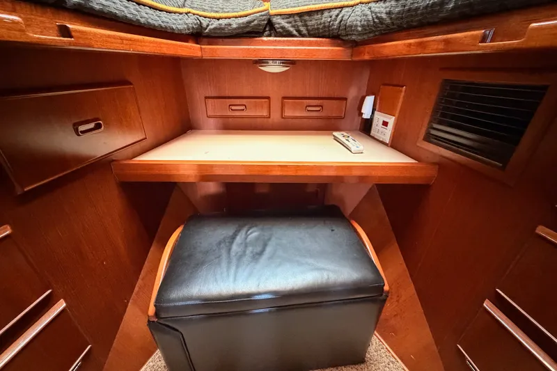 Slide: The Image of Interior of 1982 Bertram 54 Convertible yacht with wooden desk and black cushioned seat. - 71