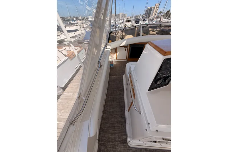 Slide: The Image of 1982 Bertram 54 Convertible yacht interior with marina view, showcasing helm and controls. - 35