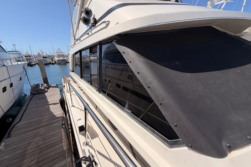 Slide: The Image of 1982 Bertram 54 Convertible yacht docked at marina, showcasing sleek design and spacious deck. - 25
