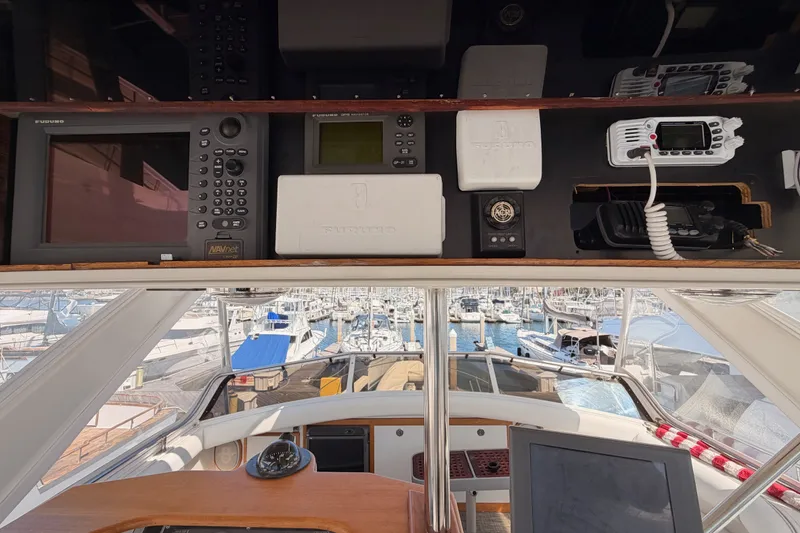 Slide: The Image of Interior view of 1982 Bertram 54 Convertible yacht with navigation equipment and marina background. - 30