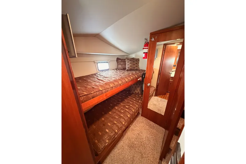 Slide: The Image of Interior of 1982 Bertram 54 Convertible yacht with cozy bunk beds and wooden finishes. - 64