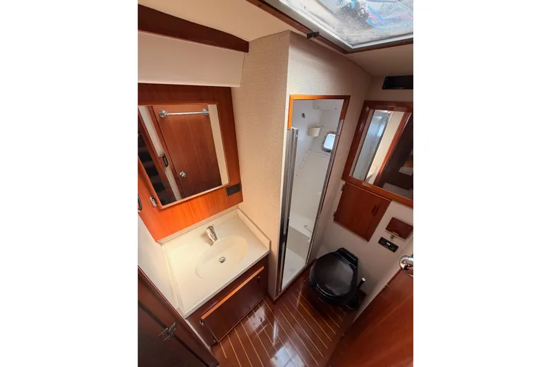 Slide: The Image of 1982 Bertram 54 Convertible yacht bathroom with wood accents and modern fixtures. - 66