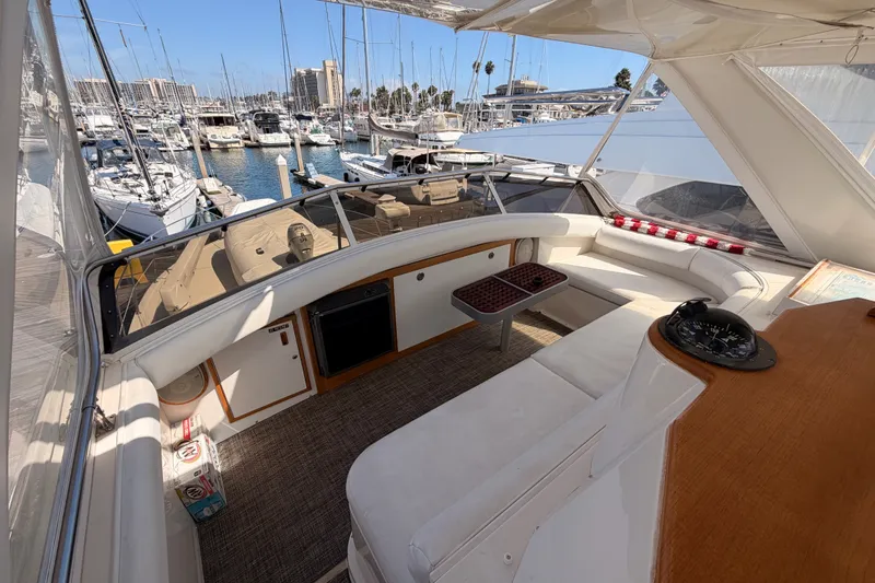 Slide: The Image of Interior of a 1982 Bertram 54 Convertible yacht at a marina, featuring seating and navigation equipment. - 36