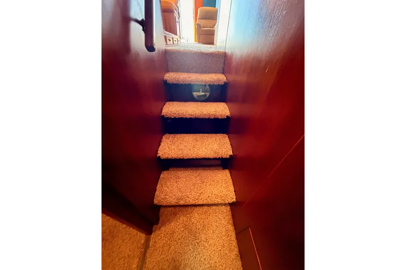 Slide: The Image of Carpeted stairs inside a 1982 Bertram 54 Convertible yacht, leading to a cozy interior. - 85