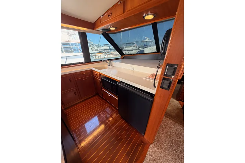 Slide: The Image of Interior of 1982 Bertram 54 Convertible yacht with wood cabinetry and modern appliances. - 57