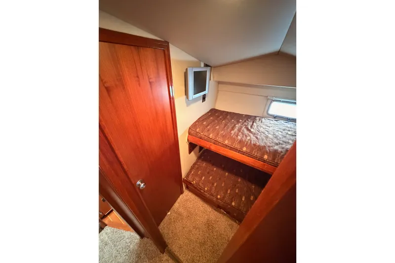 Slide: The Image of Interior of 1982 Bertram 54 Convertible yacht with bunk beds and wooden door. - 63