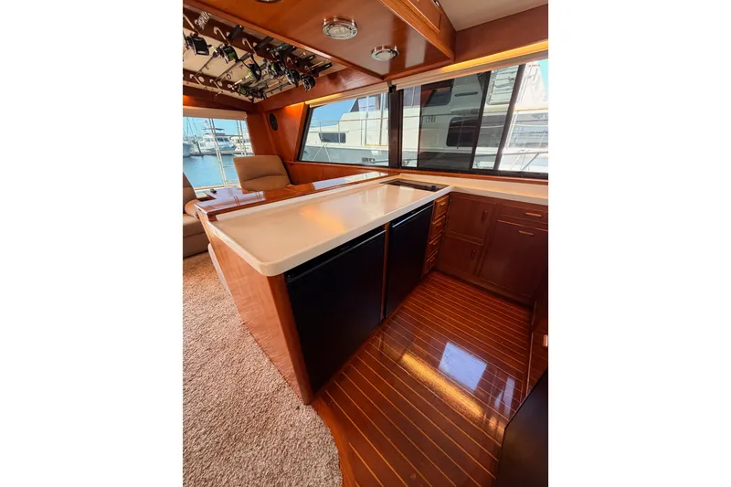 Slide: The Image of Interior of 1982 Bertram 54 Convertible yacht with wooden cabinetry and large windows. - 56