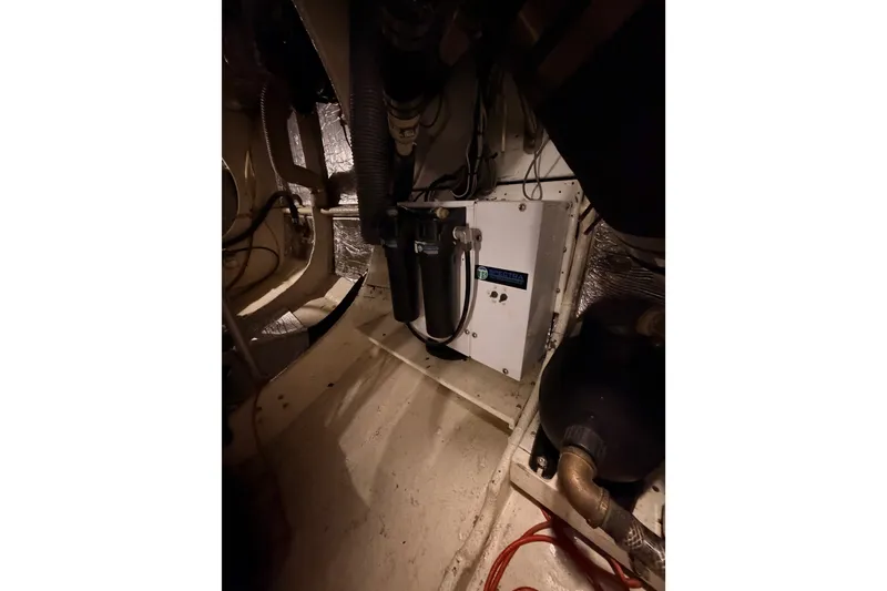 Slide: The Image of Engine room of a 1982 Bertram 54 Convertible yacht, featuring mechanical components. - 98