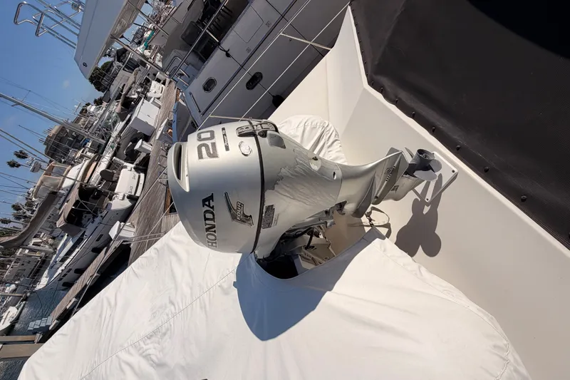 Slide: The Image of Honda 20 outboard motor on a 1982 Bertram 54 Convertible yacht at a marina. - 21