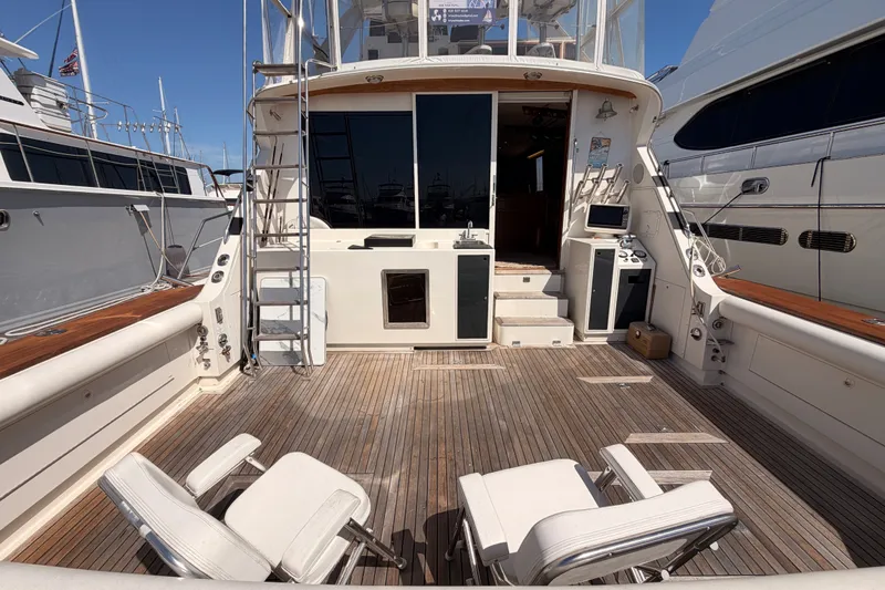 Slide: The Image of 1982 Bertram 54 Convertible yacht deck with seating and wooden flooring. - 16