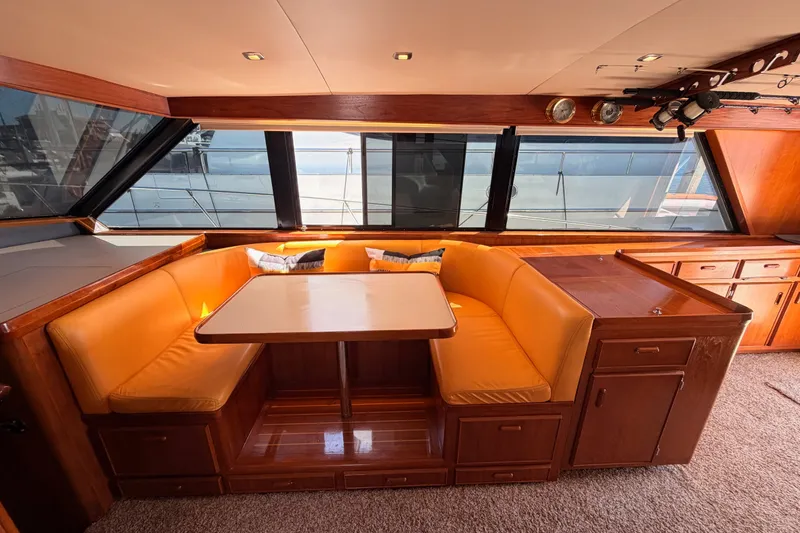 Slide: The Image of Interior of 1982 Bertram 54 Convertible yacht with cozy dining area and large windows. - 51