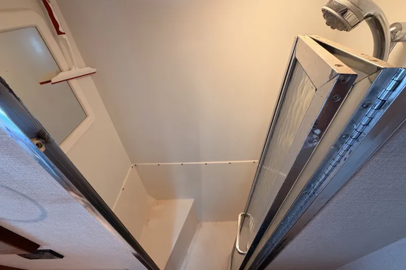 Slide: The Image of Shower area inside a 1982 Bertram 54 Convertible yacht, featuring a compact design. - 81