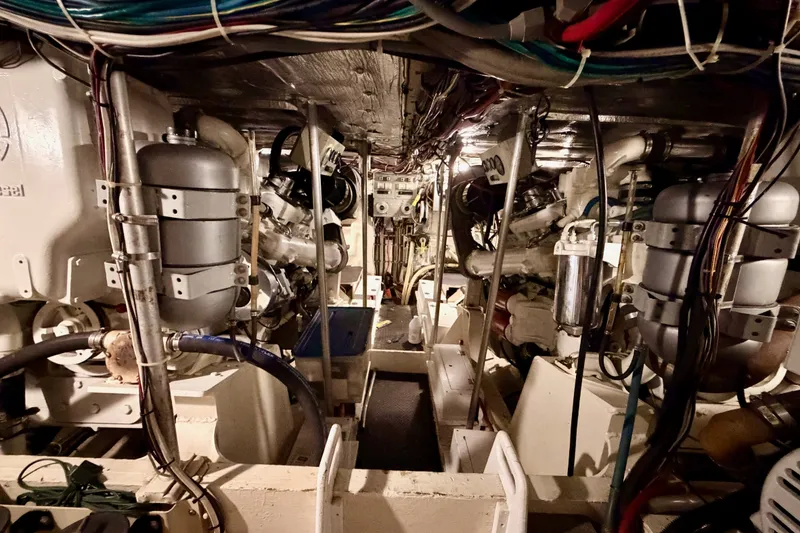 Slide: The Image of Engine room of a 1982 Bertram 54 Convertible yacht, showcasing complex machinery and wiring. - 90