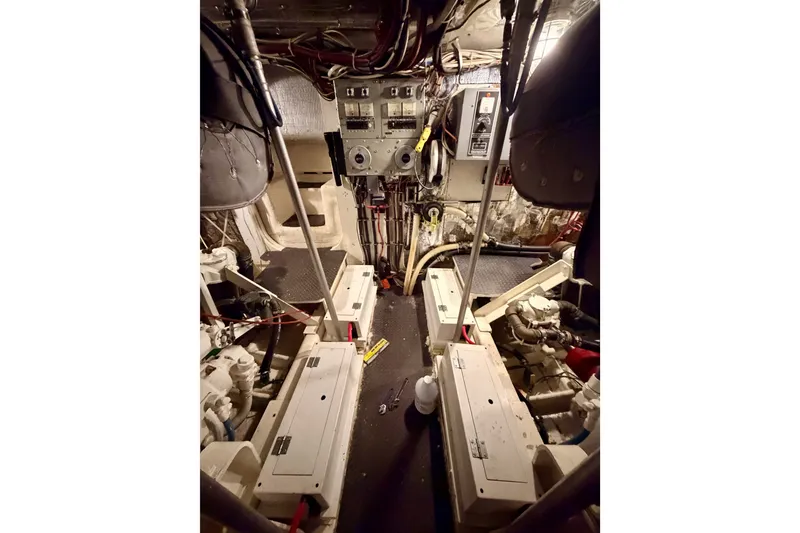 Slide: The Image of Engine room of a 1982 Bertram 54 Convertible boat, showcasing machinery and control panels. - 94