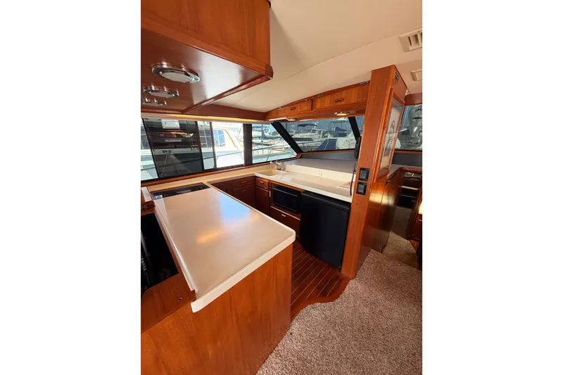 Slide: The Image of Interior of 1982 Bertram 54 Convertible yacht with wood cabinetry and modern appliances. - 54