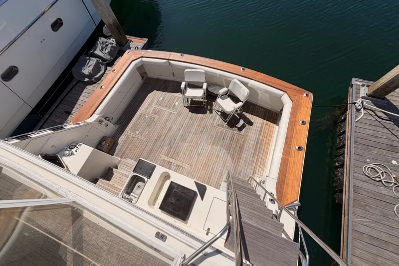Slide: The Image of 1982 Bertram 54 Convertible yacht deck with chairs and wooden flooring. - 38