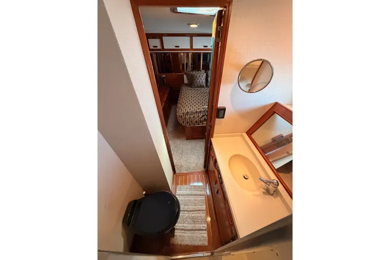 Slide: The Image of Interior of 1982 Bertram 54 Convertible yacht, featuring bathroom and bedroom view. - 82