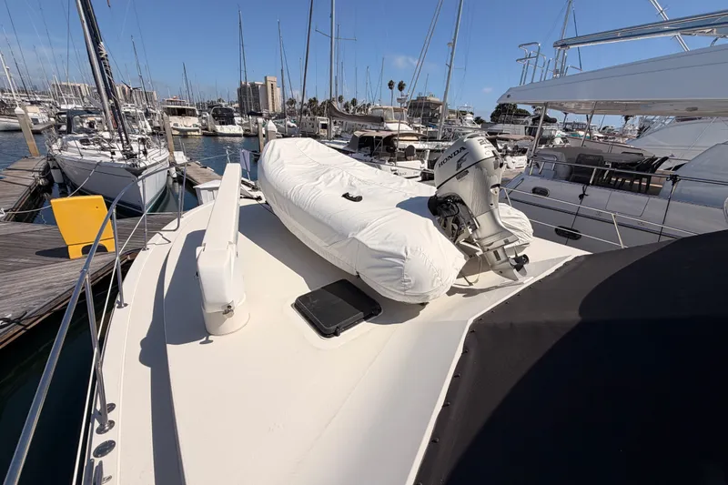 Slide: The Image of 1982 Bertram 54 Convertible yacht docked with covered dinghy and outboard motor. - 20