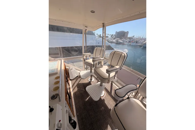 Slide: The Image of Interior view of a 1982 Bertram 54 Convertible yacht with seating and marina backdrop. - 32