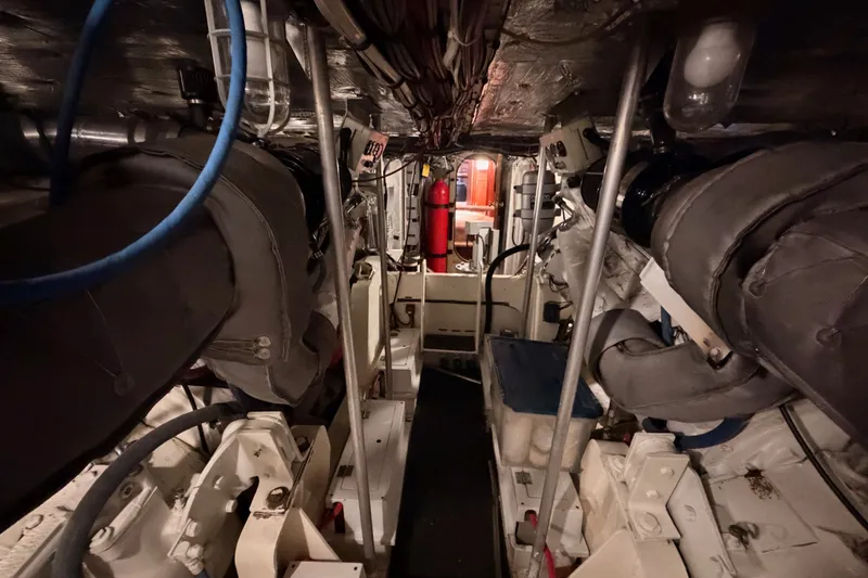 Slide: The Image of Engine room of a 1982 Bertram 54 Convertible yacht, showcasing machinery and equipment. - 100