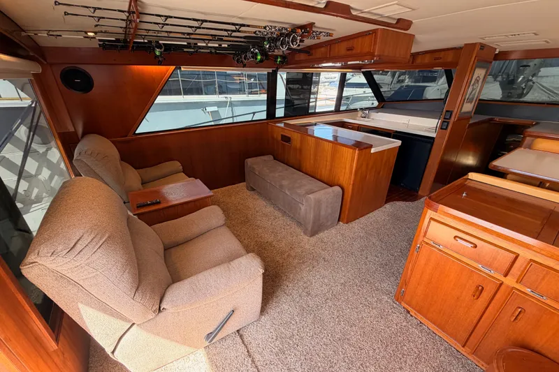 Slide: The Image of Luxurious 1982 Bertram 54 Convertible yacht interior with plush seating and fishing rods. - 49