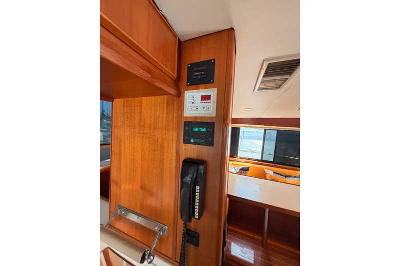 Slide: The Image of Interior of 1982 Bertram 54 Convertible yacht with control panels and vintage phone. - 60