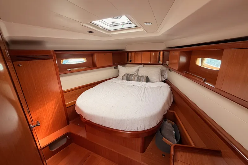 Slide: The Image of Luxurious cabin interior of a 2008 Beneteau 49 yacht with wood finish and cozy bedding. - 66