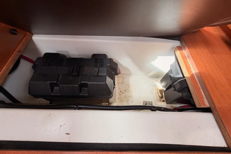 Slide: The Image of Battery compartment of a 2008 Beneteau 49 sailboat, featuring secured battery boxes. - 87