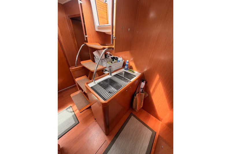 Slide: The Image of Interior of 2008 Beneteau 49 yacht with wooden finish and compact kitchen area. - 44