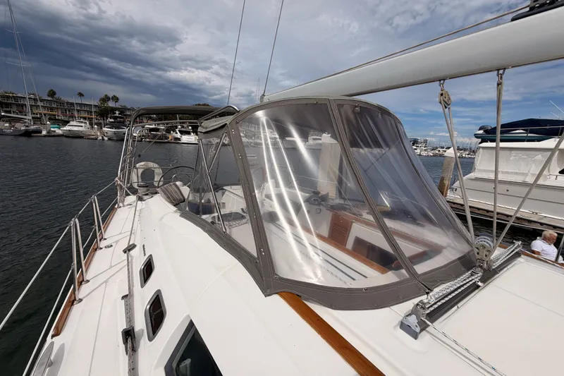 Slide: The Image of 2008 Beneteau 49 sailboat docked in marina, featuring clear cockpit enclosure. - 21