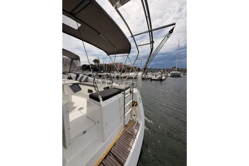 Slide: The Image of 2008 Beneteau 49 yacht docked at marina, featuring spacious deck and helm. - 25