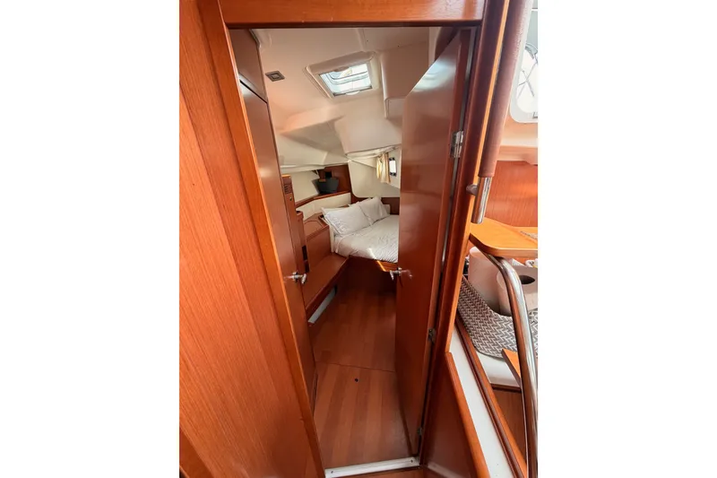 Slide: The Image of Interior cabin of 2008 Beneteau 49 yacht, featuring wooden finishes and cozy bedding. - 72