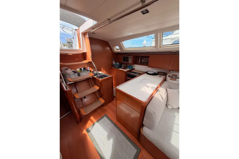 Slide: The Image of Interior of 2008 Beneteau 49 yacht, featuring a cozy kitchen and seating area. - 42