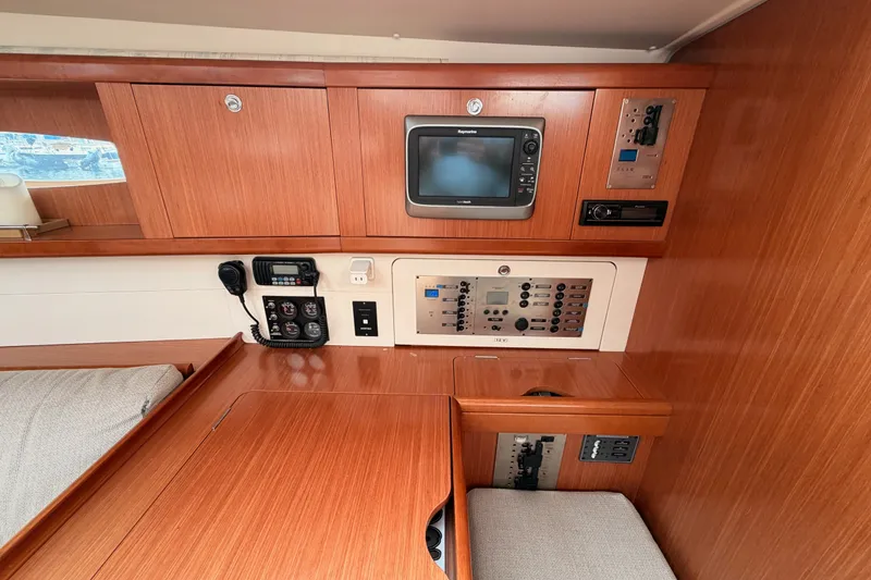 Slide: The Image of Interior view of a 2008 Beneteau 49 yacht's navigation station with control panels. - 55