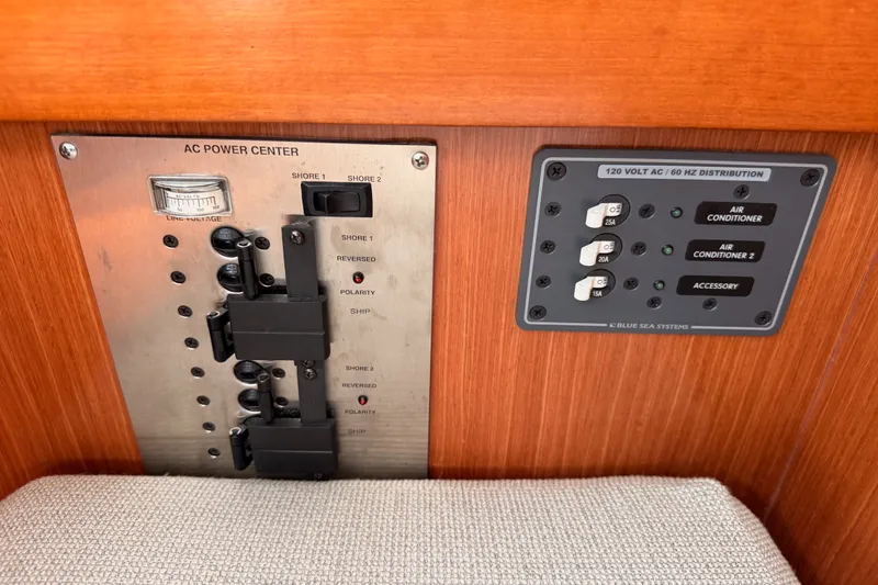 Slide: The Image of Electrical control panel on a 2008 Beneteau 49 yacht, featuring AC power center and distribution switches. - 56