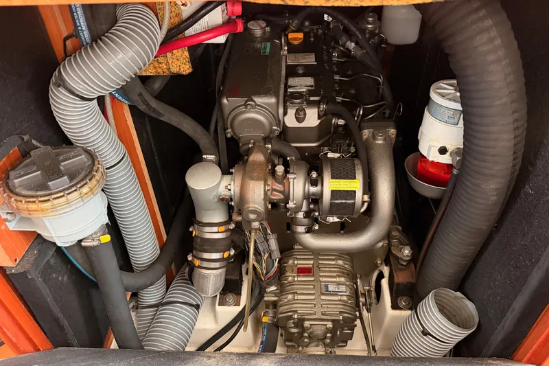 Slide: The Image of Engine compartment of a 2008 Beneteau 49 sailboat, showcasing mechanical components and hoses. - 85