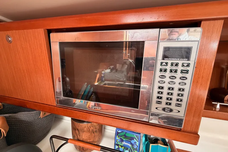 Slide: The Image of Microwave oven in 2008 Beneteau 49 yacht kitchen, surrounded by wooden cabinetry. - 49