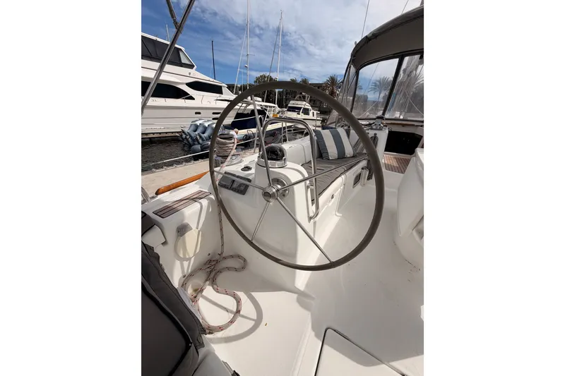 Slide: The Image of Cockpit of 2008 Beneteau 49 sailboat with steering wheel and seating at marina. - 28