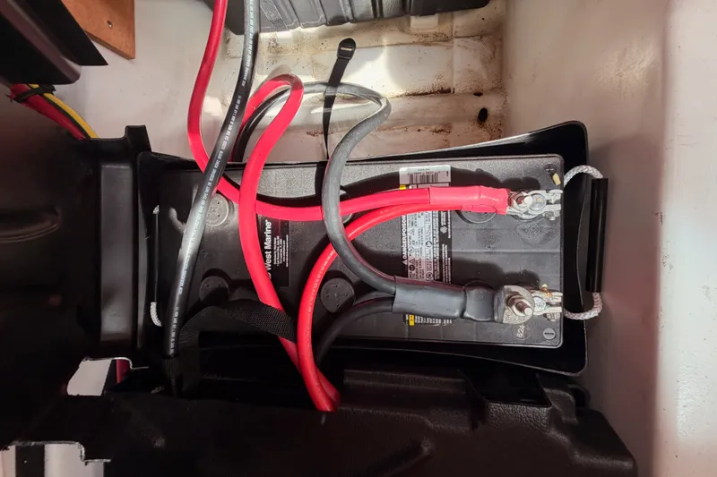 Slide: The Image of Battery compartment of a 2008 Beneteau 49 sailboat with connected cables. - 89