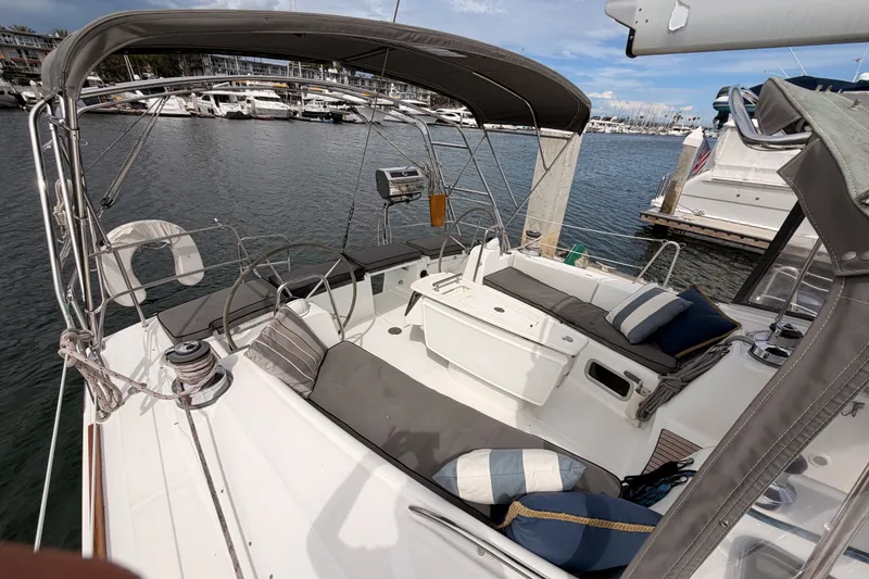 Slide: The Image of 2008 Beneteau 49 sailboat cockpit with seating, steering wheel, and marina view. - 22