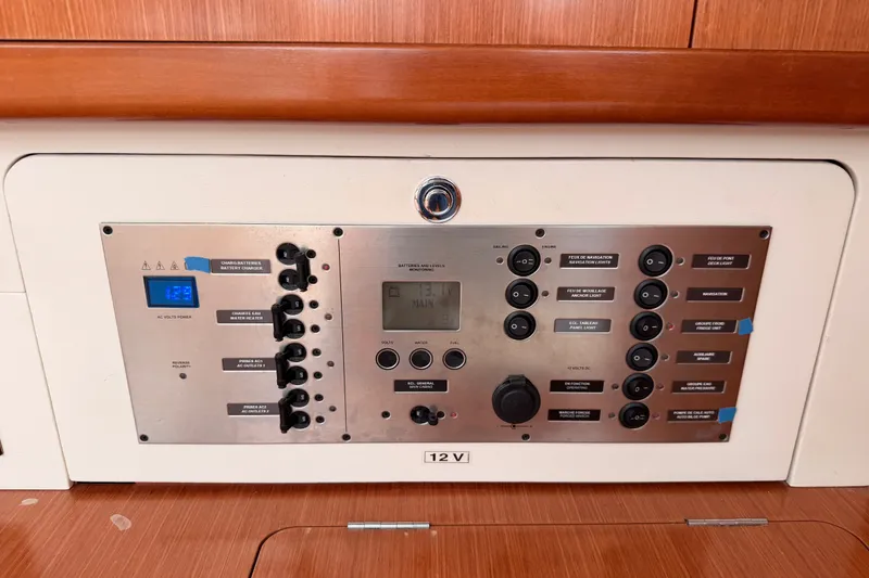 Slide: The Image of Control panel of a 2008 Beneteau 49 yacht, featuring various switches and displays. - 58