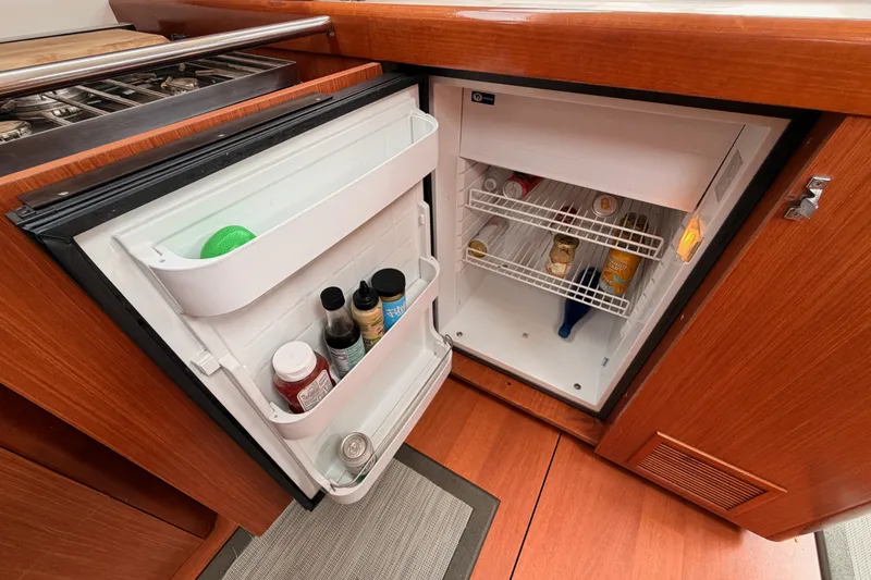 Slide: The Image of Open refrigerator in 2008 Beneteau 49 yacht kitchen, stocked with condiments and beverages. - 47
