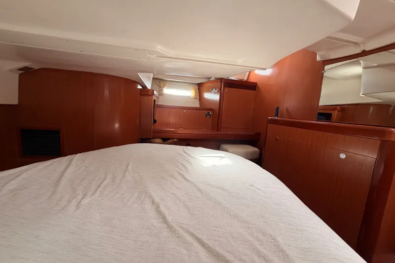 Slide: The Image of Interior cabin of a 2008 Beneteau 49 yacht, featuring wood paneling and a cozy bed. - 75