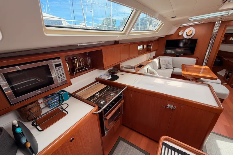 Slide: The Image of Luxurious interior of a 2008 Beneteau 49 yacht featuring a modern kitchen and cozy seating area. - 45