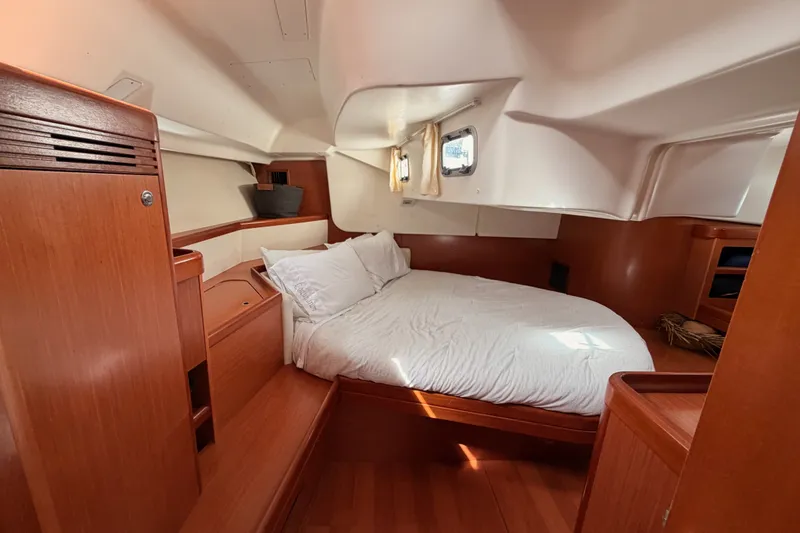 Slide: The Image of Luxurious cabin interior of a 2008 Beneteau 49 yacht with wooden finishes and cozy bedding. - 73
