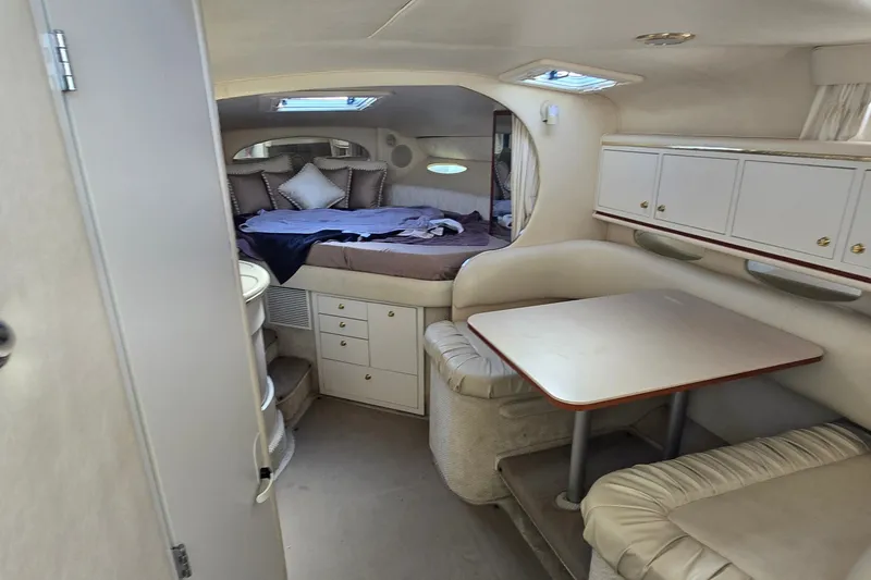 Slide: The Image of Interior of 2001 Sea Ray Sundancer 310, featuring cozy cabin with bed and dining area. - 19