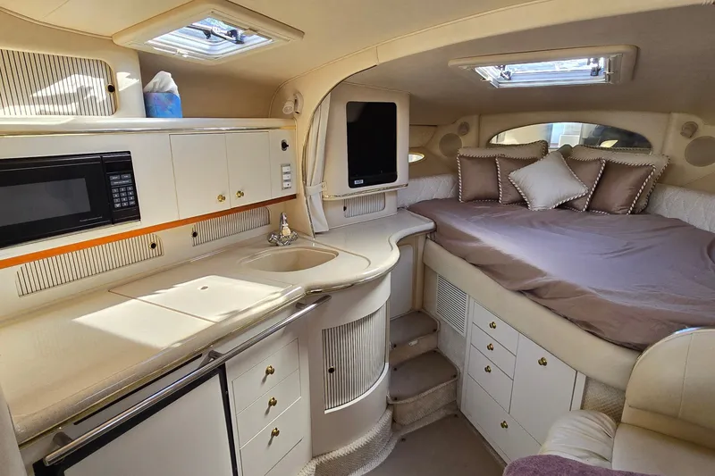 Slide: The Image of Luxurious 2001 Sea Ray Sundancer 310 cabin interior with kitchenette and cozy sleeping area. - 26