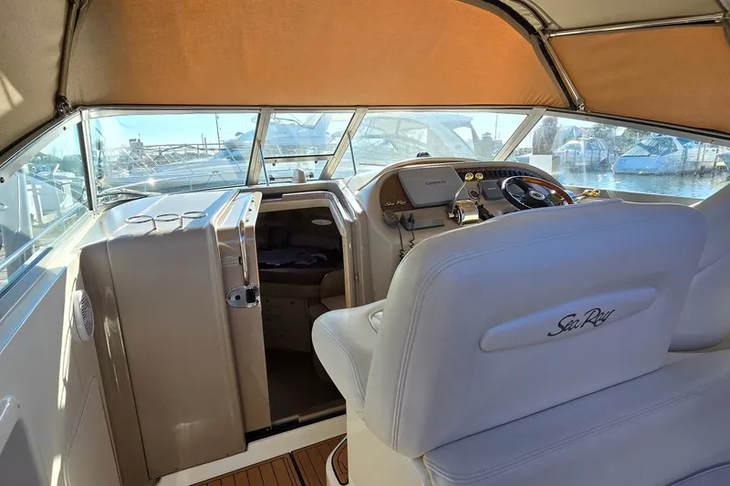 Slide: The Image of 2001 Sea Ray Sundancer 310 cockpit with helm, beige seating, and marina view. - 17