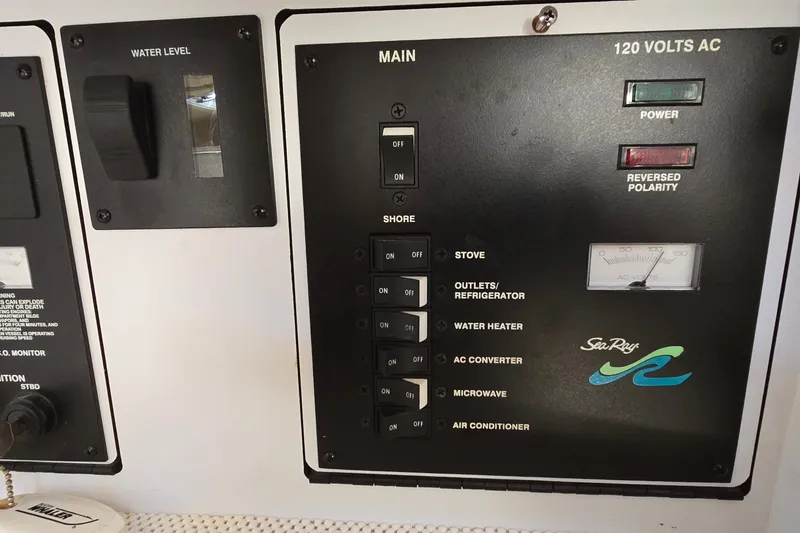Slide: The Image of Control panel of a 2001 Sea Ray Sundancer 310 boat, showing electrical switches and water level indicator. - 34