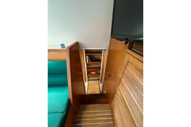 Slide: The Image of Interior of 2004 Manta 42 MkII yacht with wooden cabinetry and teal seating. - 23